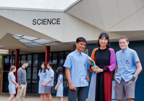 Female teacher with high school students in front of Science building