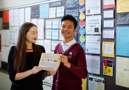 Female teacher standing with high school student