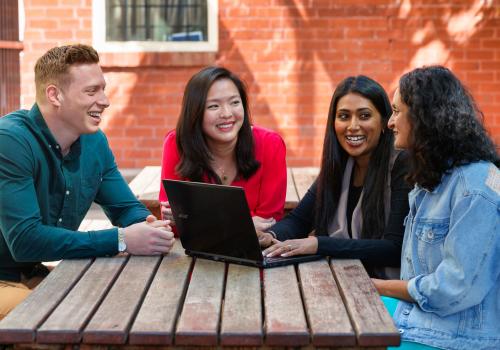 Teachers having discussion at a table outdoors