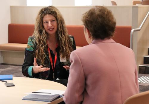2 participants seated at table in discussion