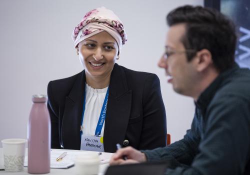 2 participants seated at table in discussion