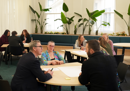 Groups of participants seated at tables during a workshop
