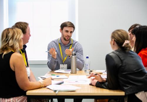 A group of participants seated at a table in discussion during a workshop
