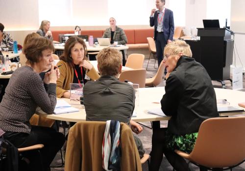 A group of participants seated at a table in collaboration during a workshop