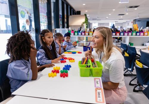 Teacher working on counting with primary school students at their desks
