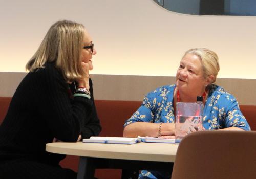 2 participants seated at table in discussion