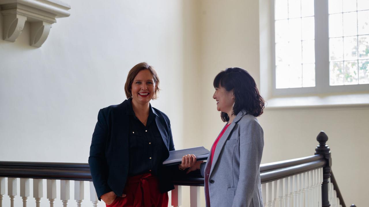 2 participants standing in front of staircase