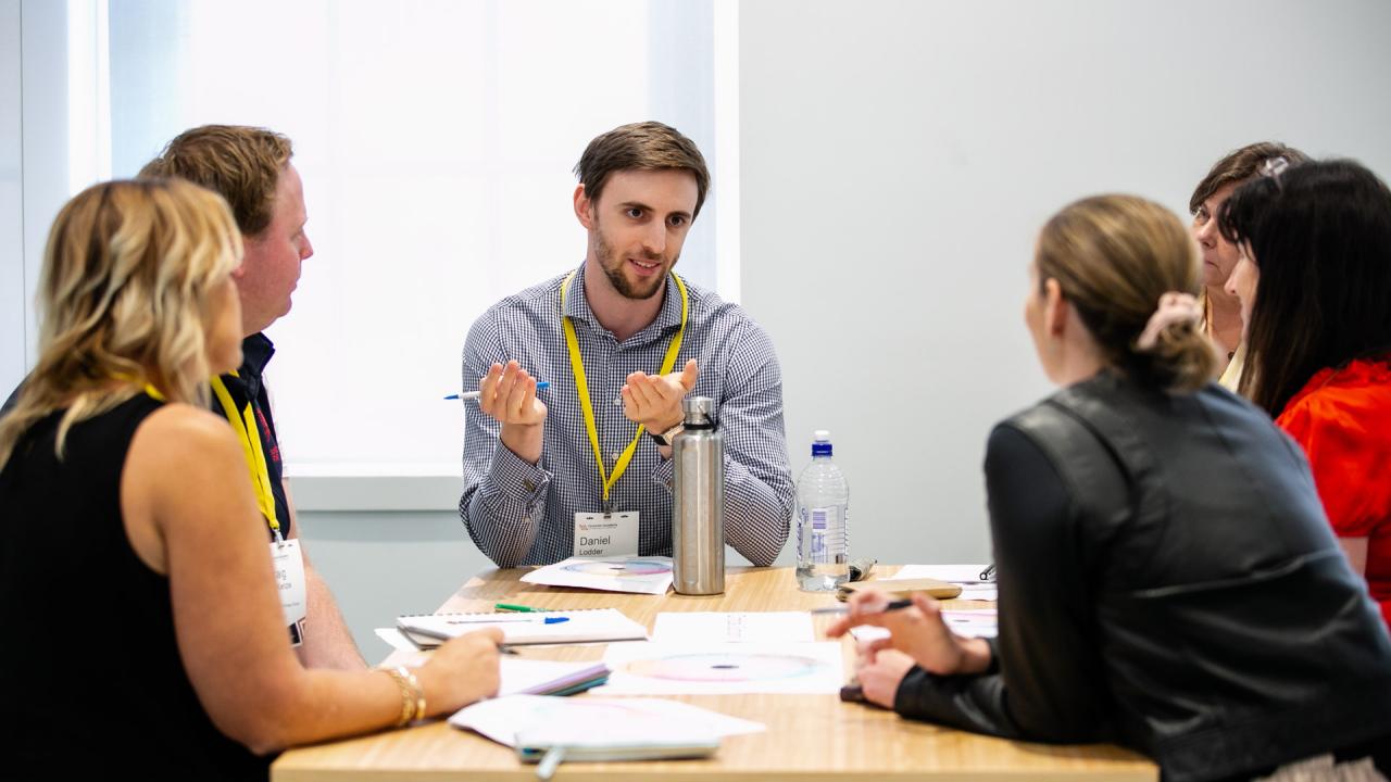 A group of participants seated at a table in discussion during a workshop