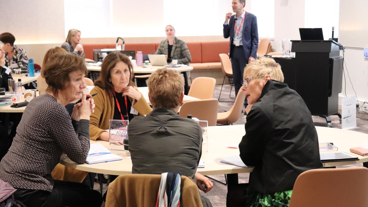 A group of participants seated at a table in collaboration during a workshop