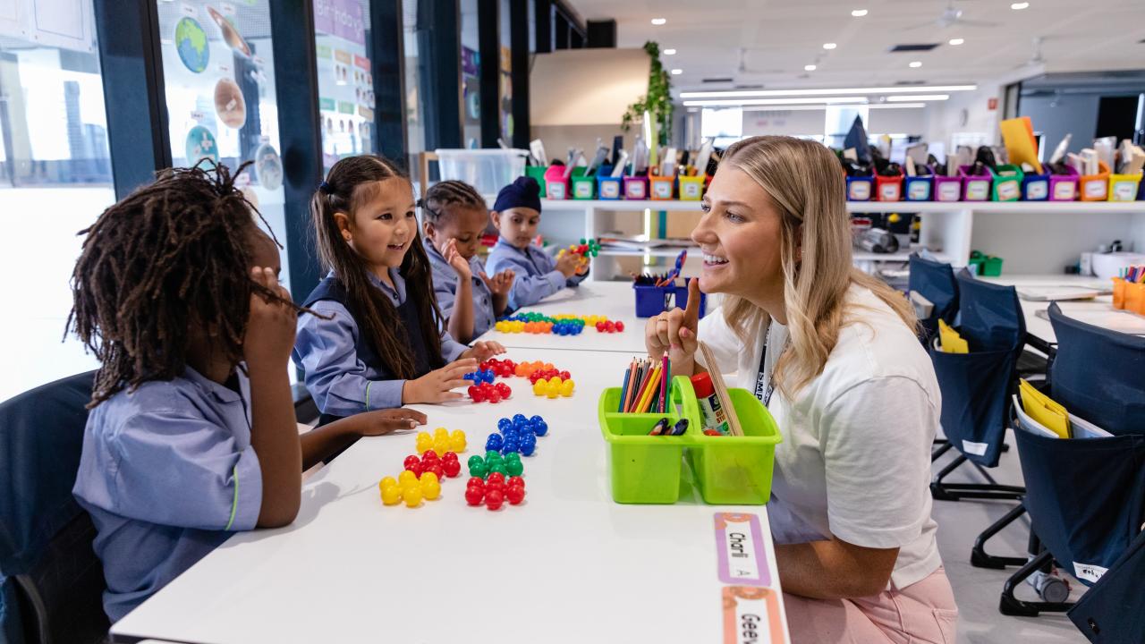 Teacher working on counting with primary school students at their desks
