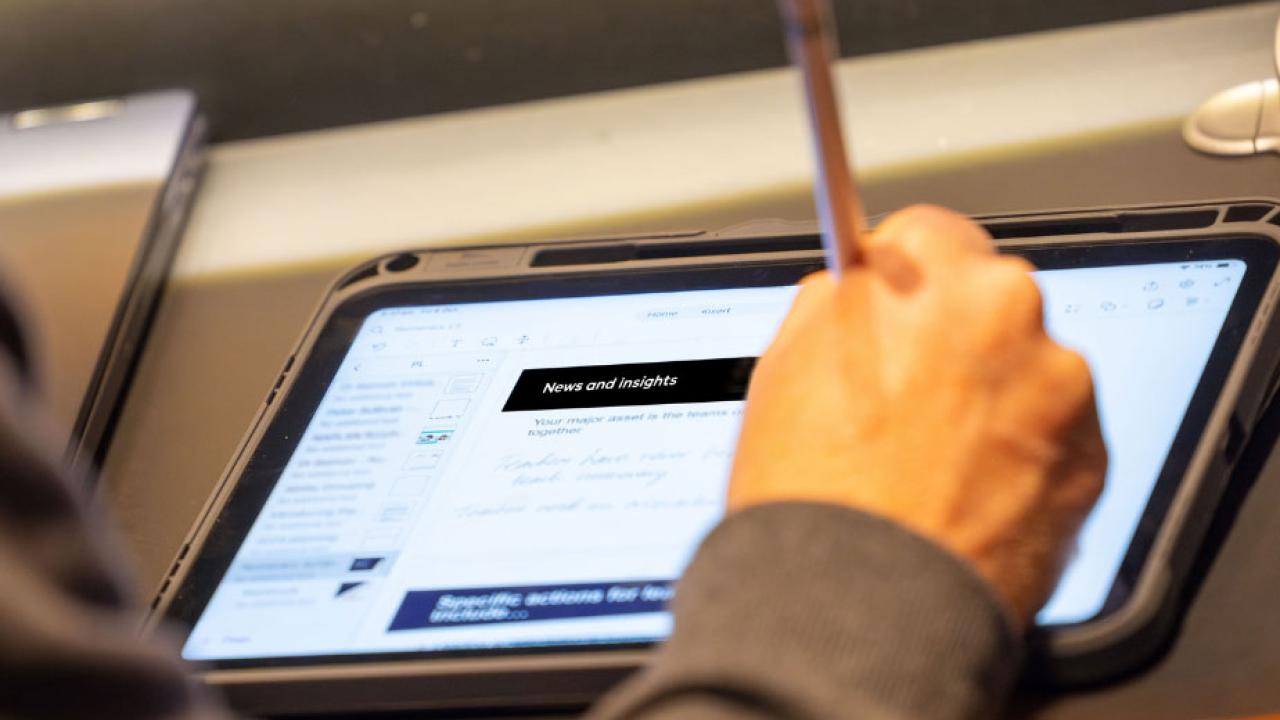 Person writing notes in a tablet