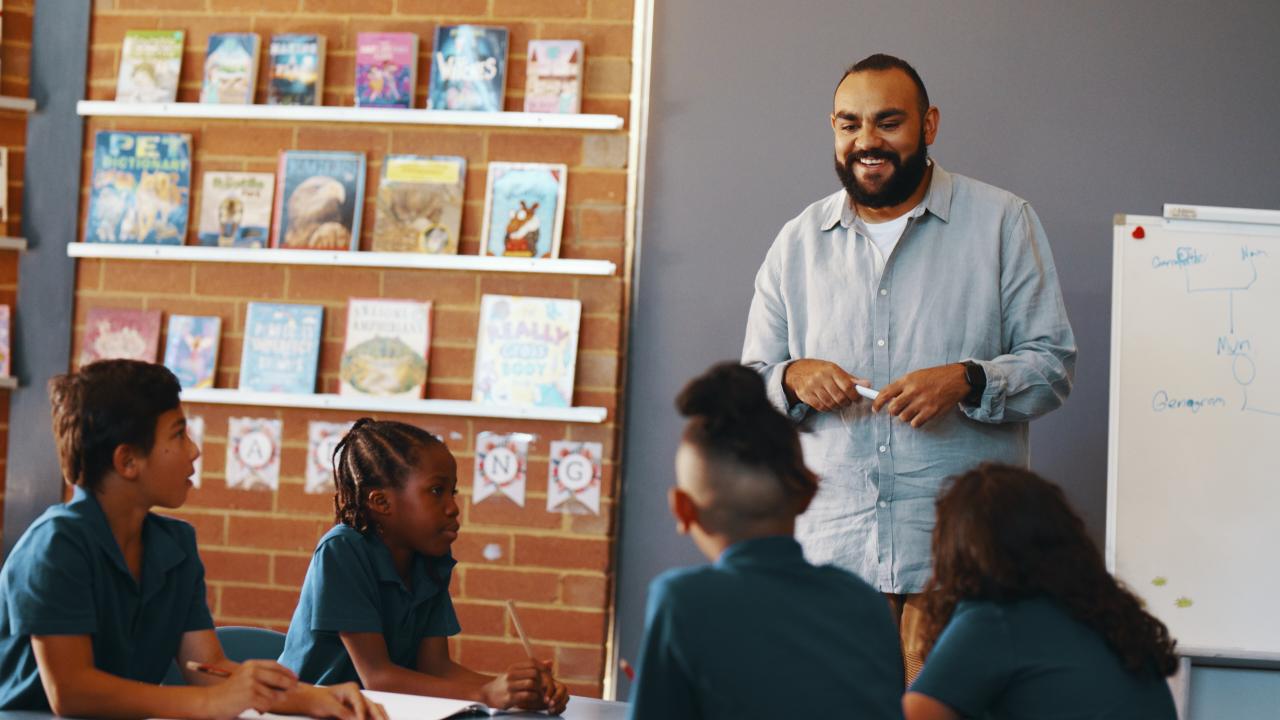 Teacher standing in front of class of primary students