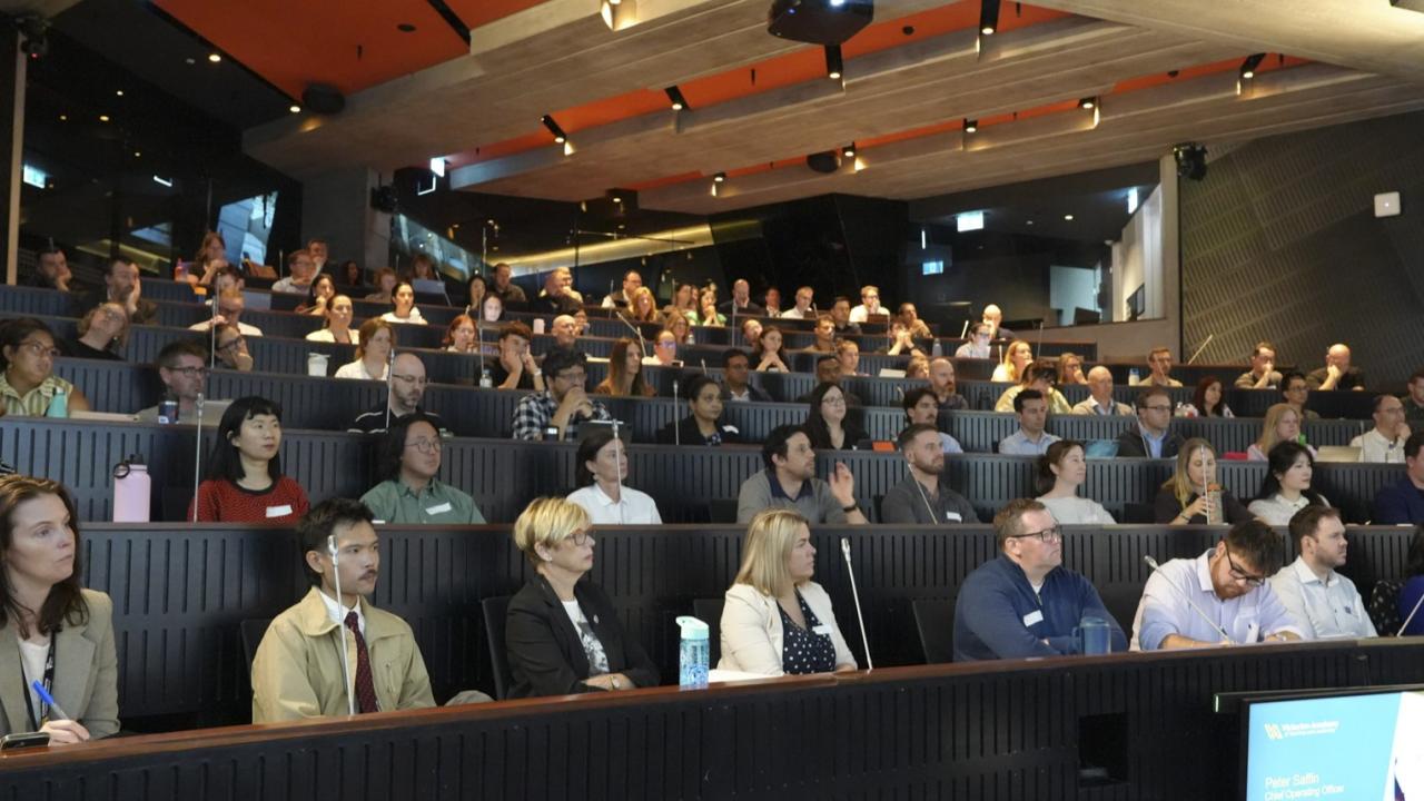 Participants sitting in a theatre style auditorium at an event 