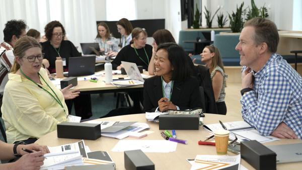 Photo of three TIF fellows sitting at a table in a workshop setting