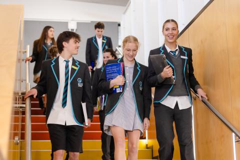 Secondary students walking down steps at school