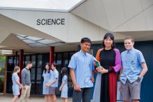 Female teacher with high school students in front of Science building