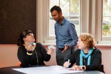 Three adults collaborating around a table. 
