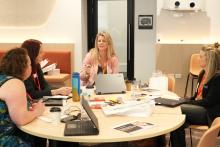 A group of participants seated at a table in discussion during a workshop