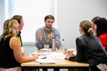 A group of participants seated at a table in discussion during a workshop