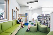 Primary students sitting and reading in the school library