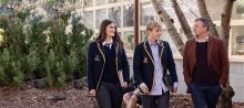 Principal of Sandringham leading through the school paved area with 2 students
