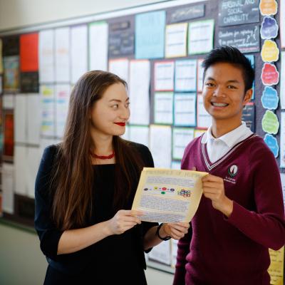 Female teacher standing with high school student