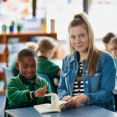Female teacher reading with primary student