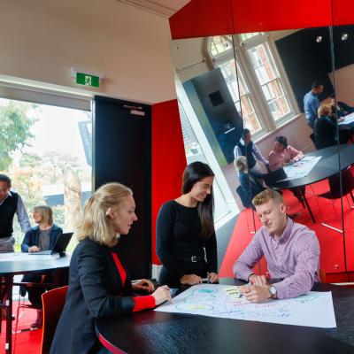 Adults learning together around tables.