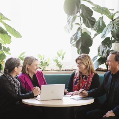 Groups of 4 participants seated at a table in discussion