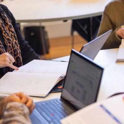 People working with computers and documents in a desk
