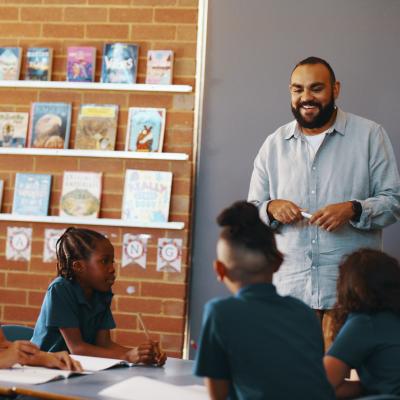Teacher standing in front of class of primary students