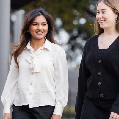 2 school teachers walking side by side outside on school grounds 
