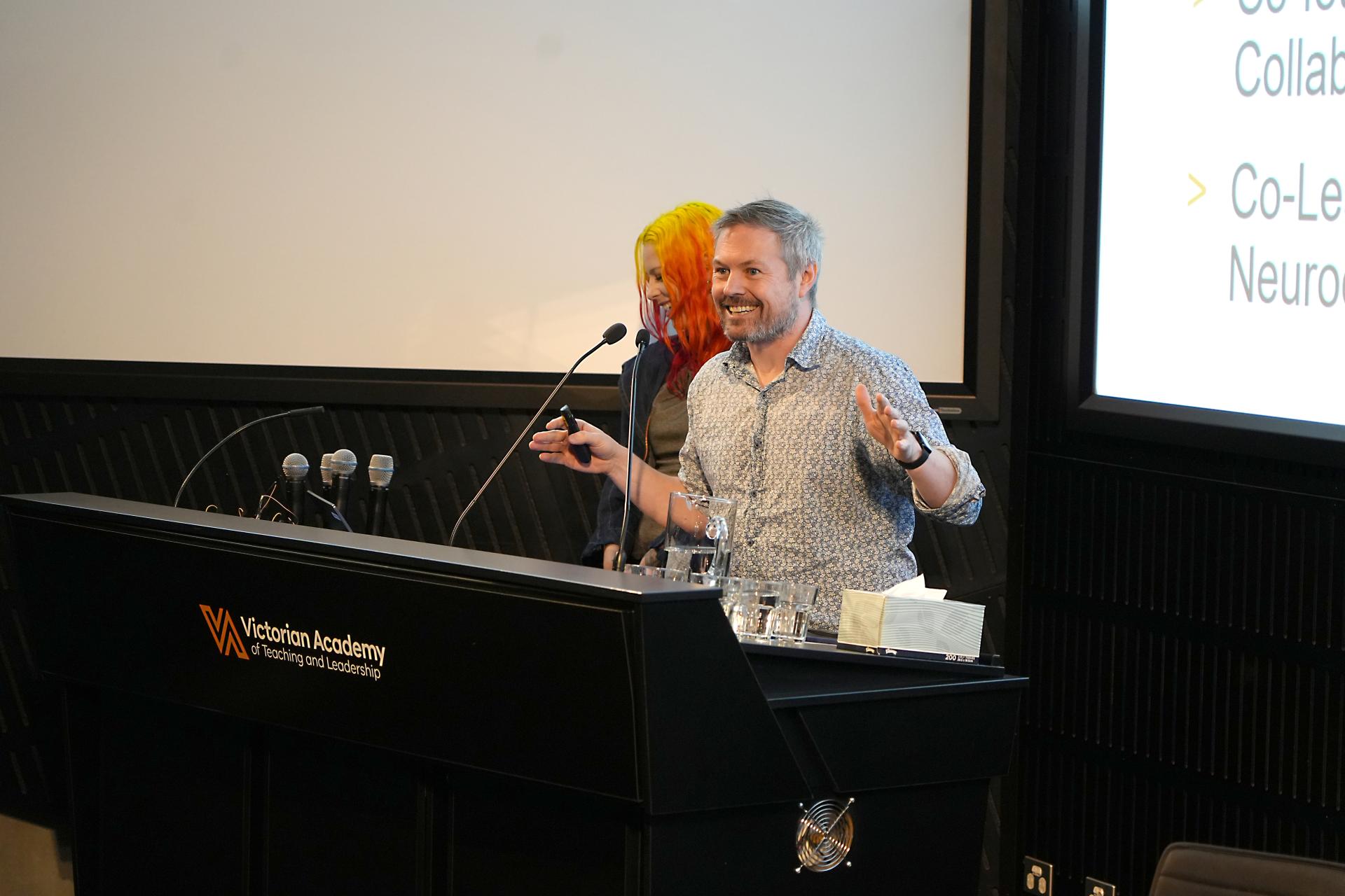 A/prof Matthew Harrison speaking at a lectern 