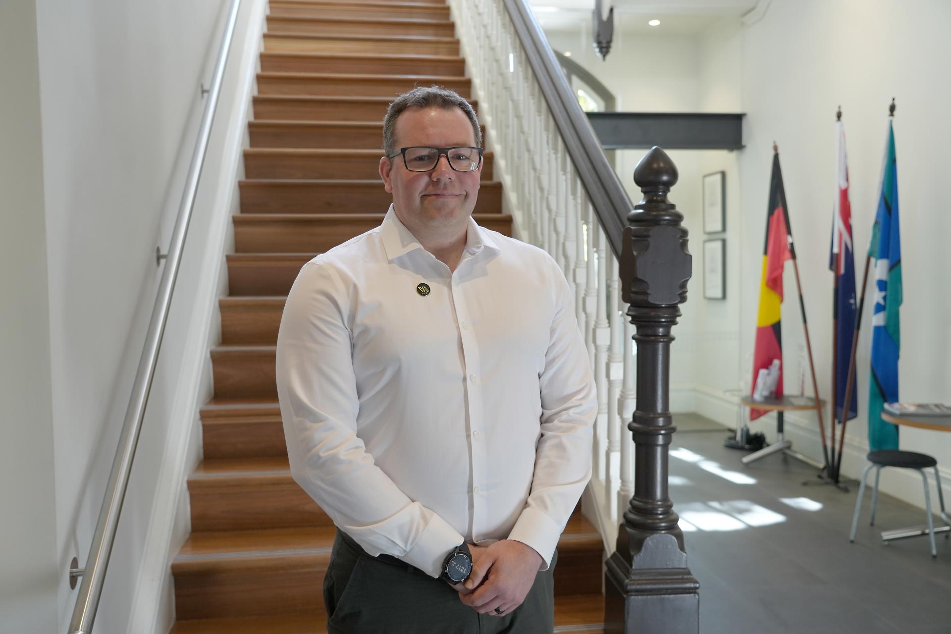 Mark Smith standing in front of a staircase