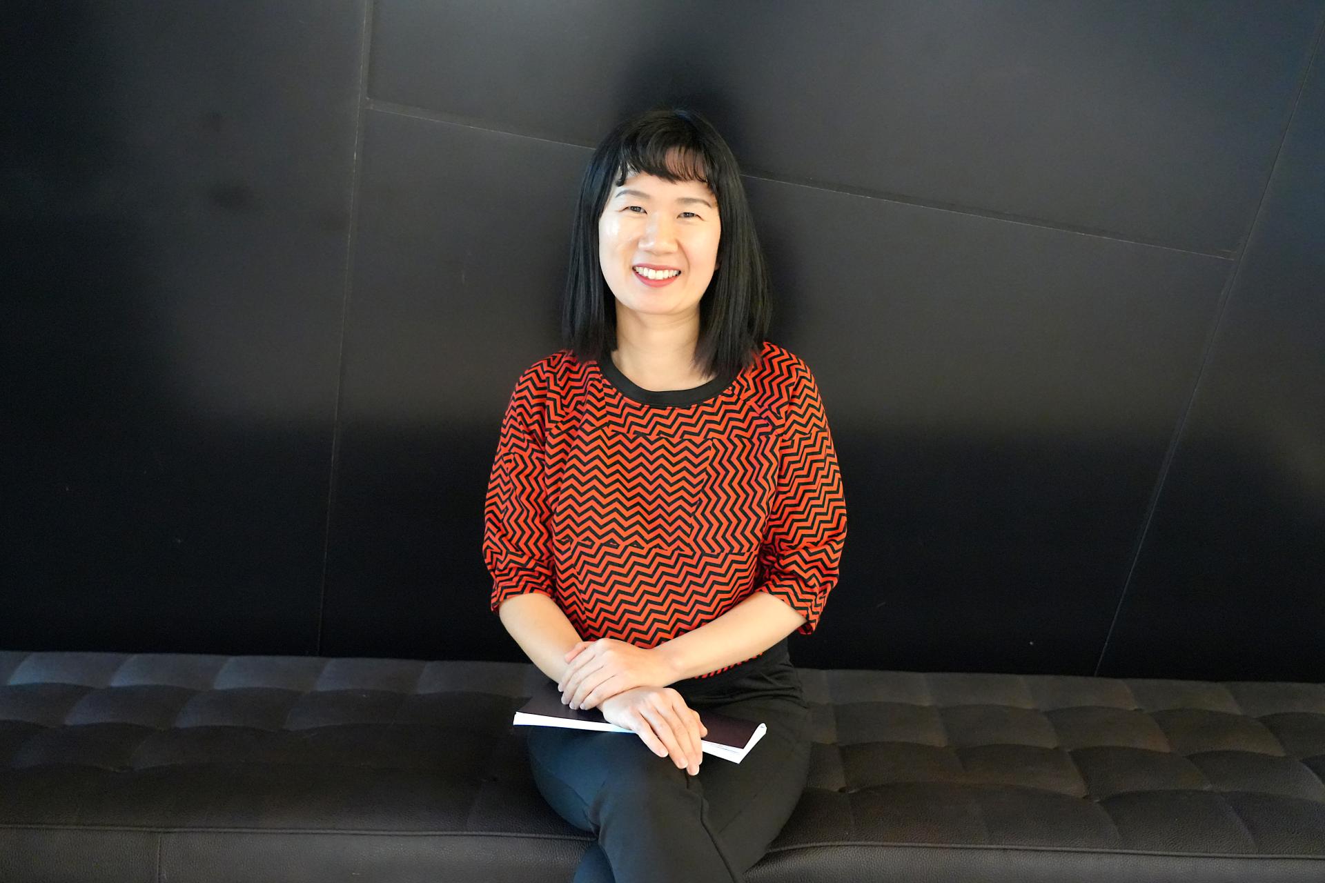 Lydia Lim seated in front of black background